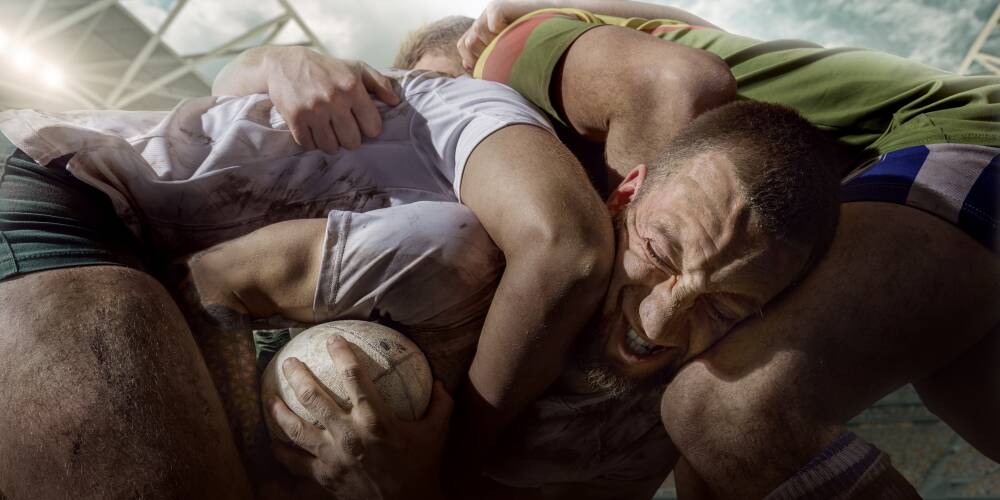 Rugby players fight for the ball on professional rugby stadium