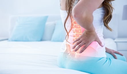 Digital,Composite,Of,Highlighted,Spine,Of,Woman,With,Back,Pain